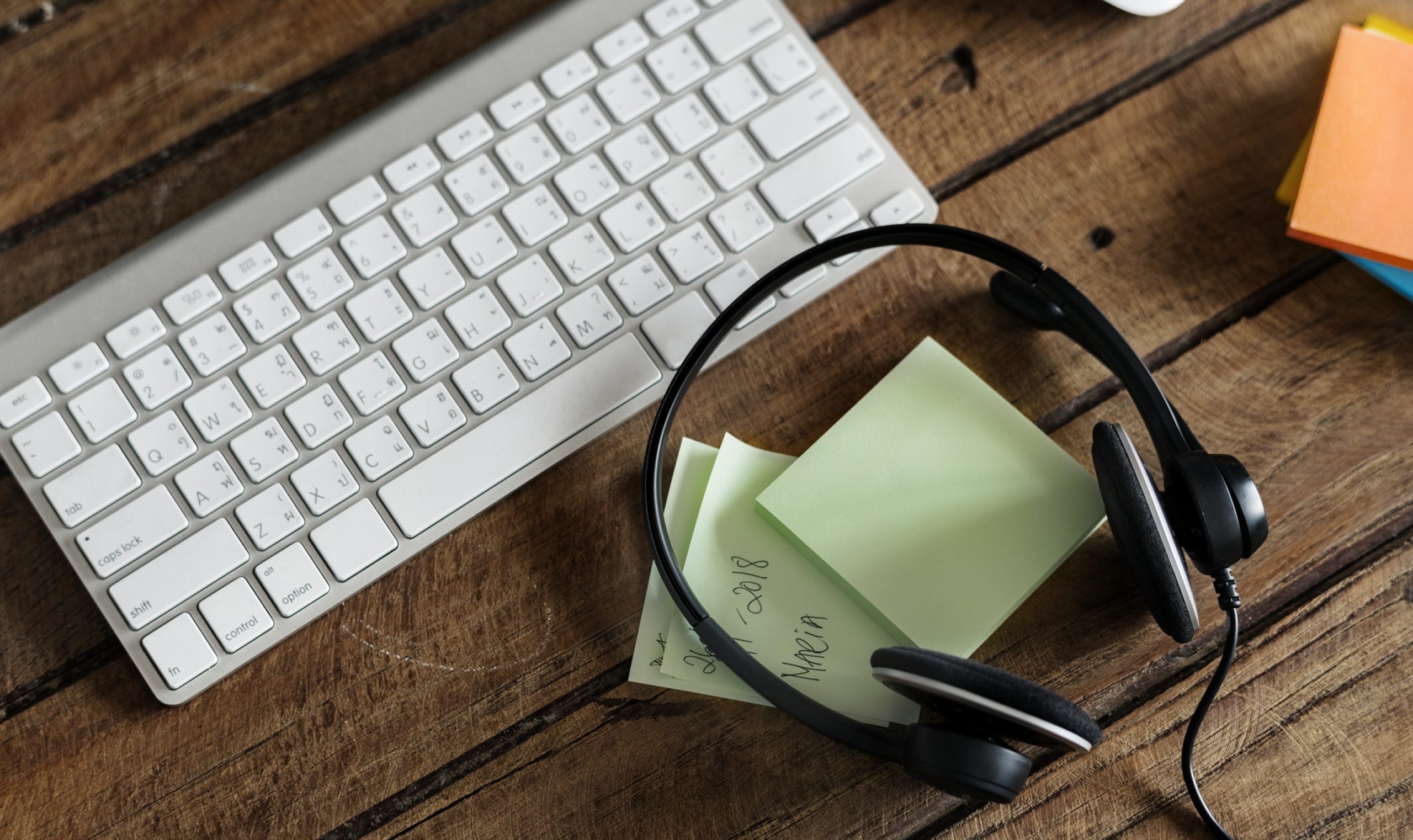 Aerial view of headphones and keyboard on wooden table Aerial view of headphones and keyboard on wooden table